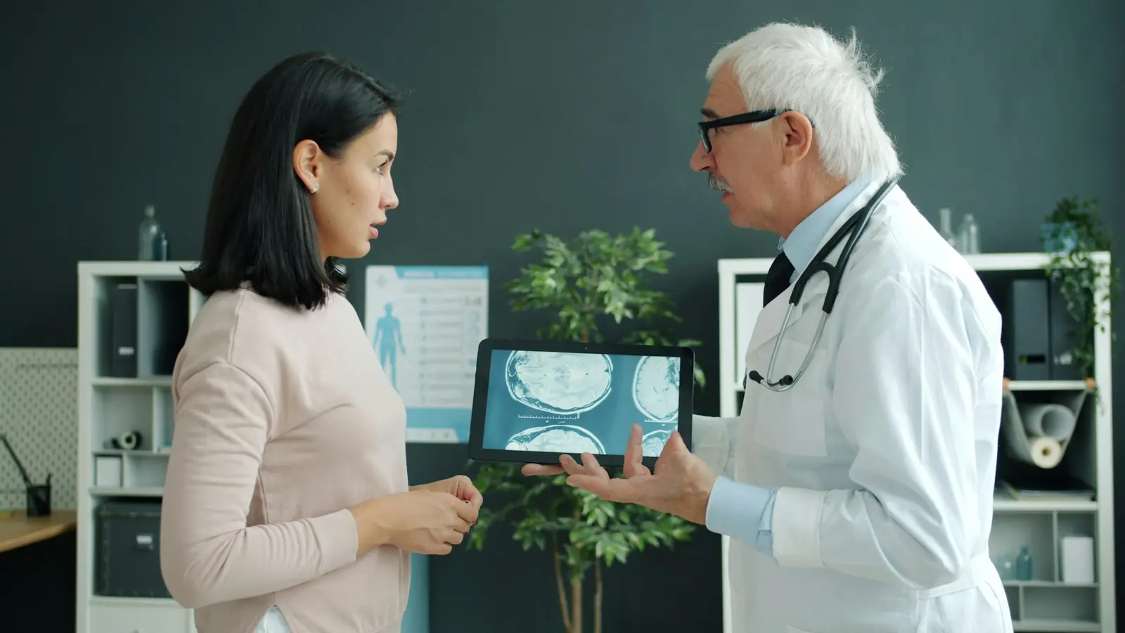 Médico mostrando um exame em um tablet para uma paciente.