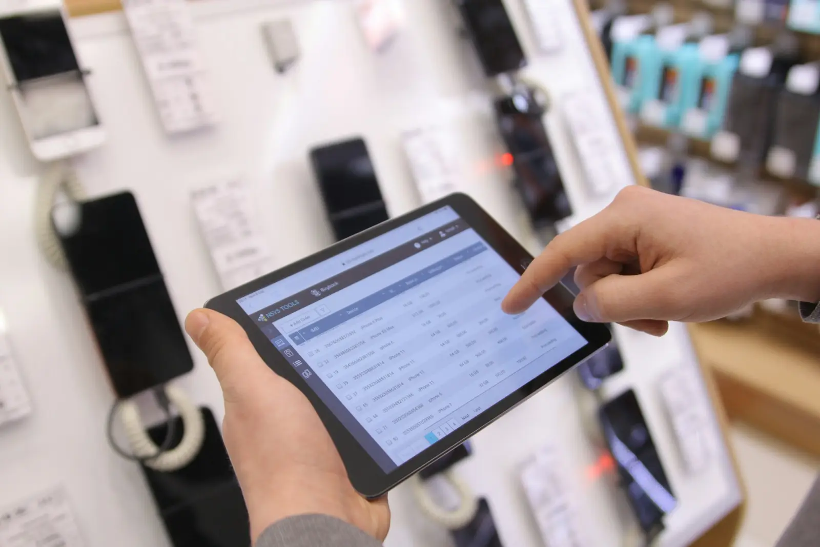 Pessoa usando um tablet em uma loja de eletrônicos.